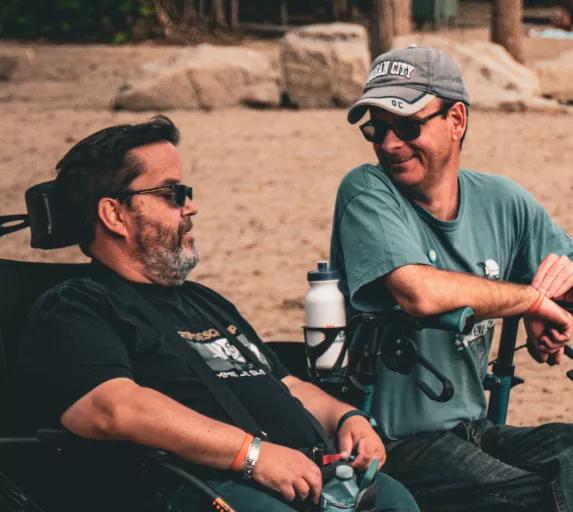 Discussion entre deux hommes en fauteuil roulant.